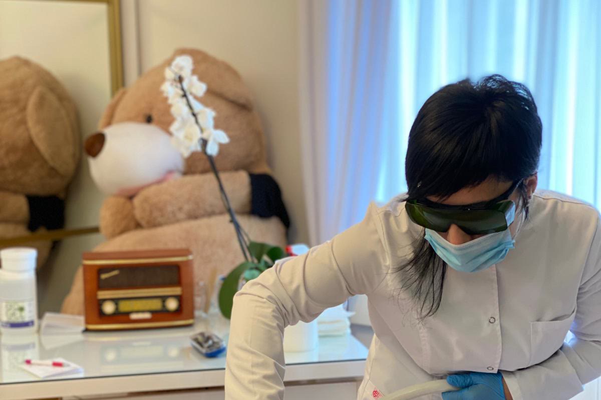 Laserska glava i ruke u rukavicama tokom dokumentovanog tretmana